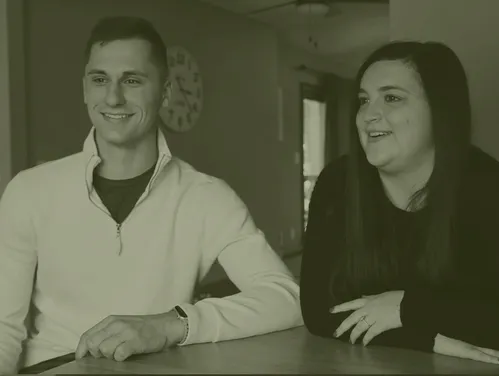 A man and woman sitting at a table smiling