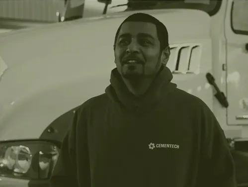 A man smiling, wearing a CementTech hoodie