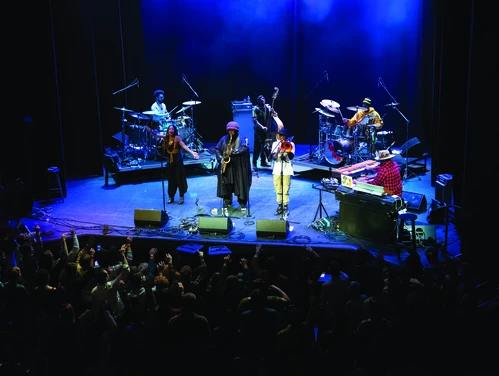 Musicians performing on stage with blue lighting