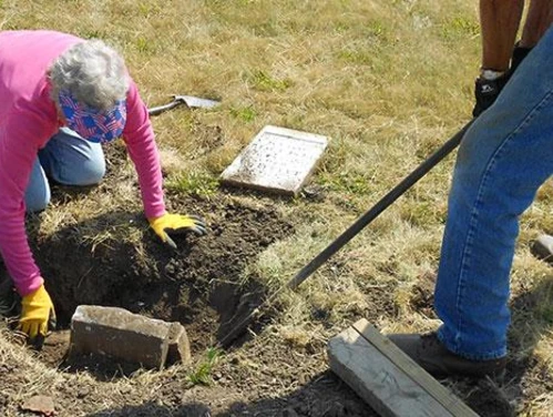 People working on restoring an old grave site