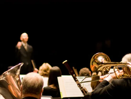 Orchestra musicians with a conductor