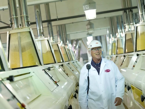 Supervisor in a factory next to machinery making pasta