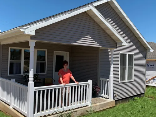 Lady standing on porch of new cottage home