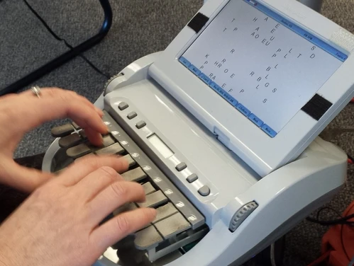Hands typing on a stenographer's machine