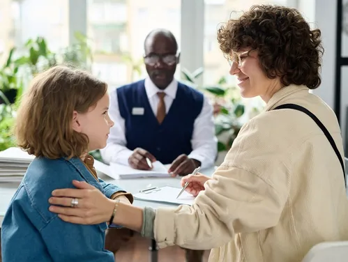 Child and adult with authority figure wearing nametag sitting at a desk