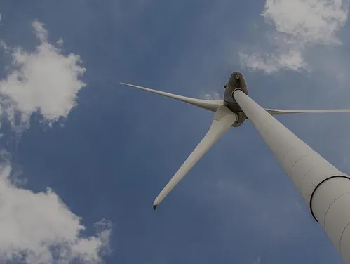 Wind Turbine against a blue sky with fluffy clouds