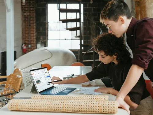 Man and woman looking at computer on worktable in small business