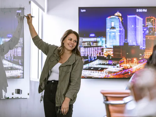 woman pointing at a presentation in a conference room