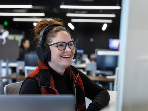 woman working at a desk with headphones