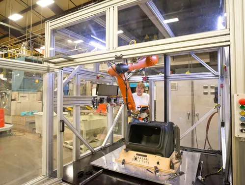 Factory worker using a robotic arm