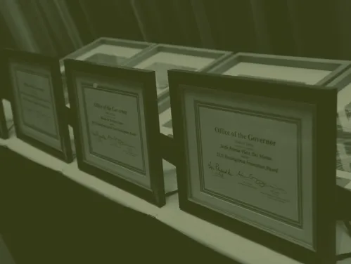 Awards from Office of the Governor displayed on a table