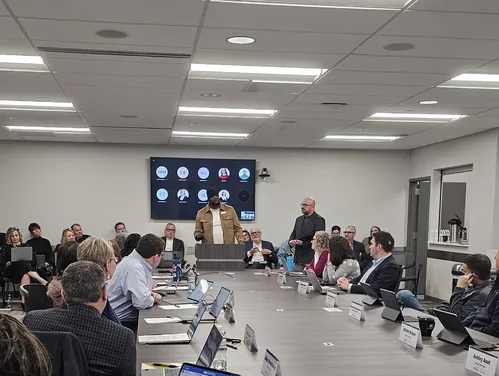 IHAF board meeting - man at podium speaking to attendees sitting around table