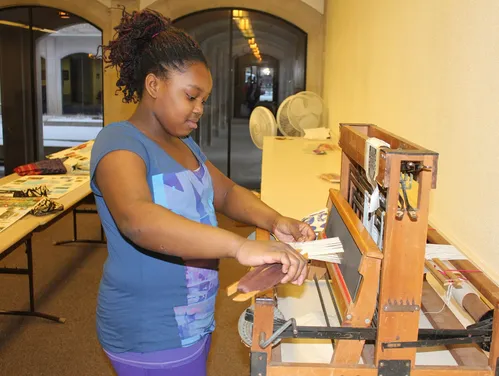 Girl working at a weaving loom
