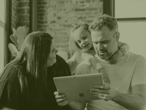 Mom, dad, and daughter looking at laptop