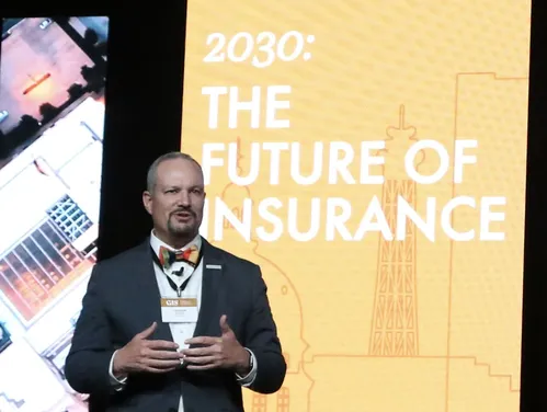 Jason Gross in front of a screen that reads 2030: The Future of Insurance