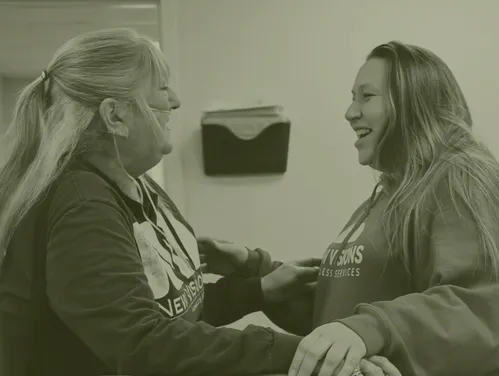 Two ladies hugging in office setting