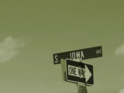 One Way street sign underneath S Iowa Ave sign