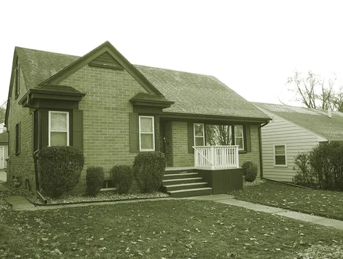 Brick story and half home with sidewalk
