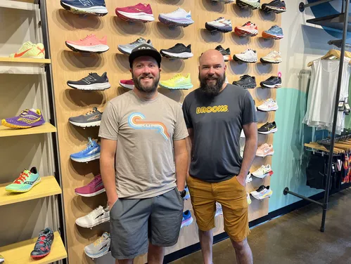 Jim Dwyer and Clifton Trebil-Smith, co-owners of Iowa Running Company in front of a wall of running shoes