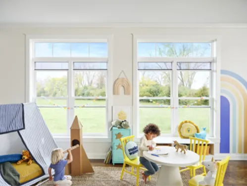 Children playing in a rainbow filled playroom with large open windows