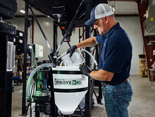 Man in hat wearing gloves and mixing product in a container that reads PROVEN 40