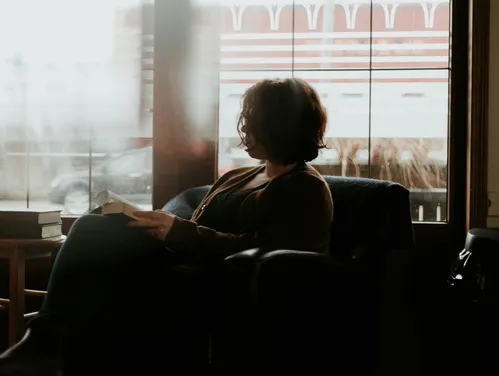 Woman reading a book in comfy chair