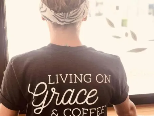 The back of a tee shirt reading Living on Grace & Coffee