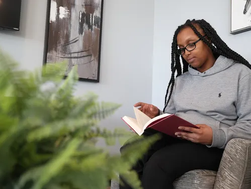 Woman reading a book while sitting in an armchair