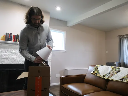 Man unpacking a lamp from a cardboard box