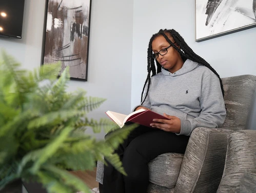 woman reading a book in her home