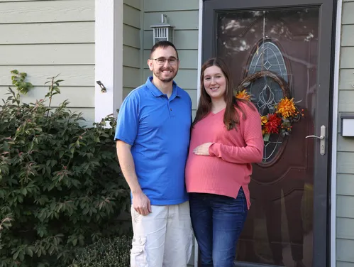 a couple standing by their front door