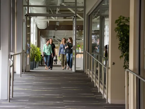 people walking down a hallway in an office building