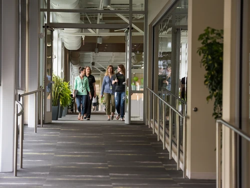 people walking down a hallway in an office building