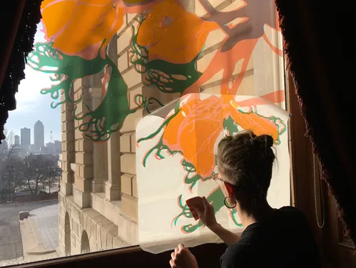artist painting on a window