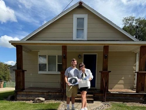 a couple standing in front of their home
