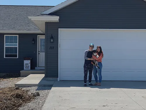 Family standing in front of house.