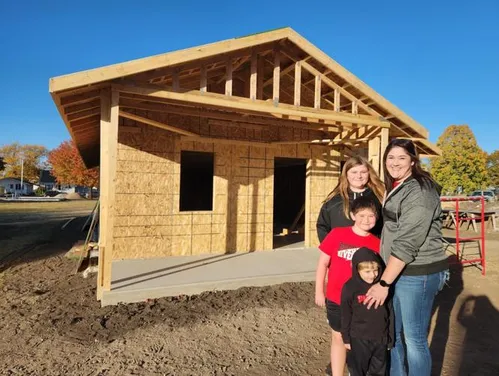 Family standing in front of newly built house.