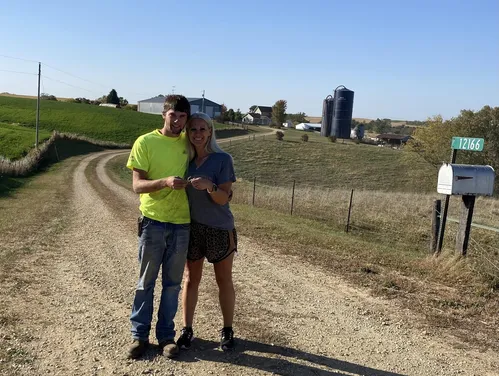 Two people standing side by side on gravel road