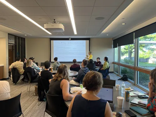 a conference room full of people with a presenter