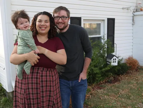 family of three outside of house