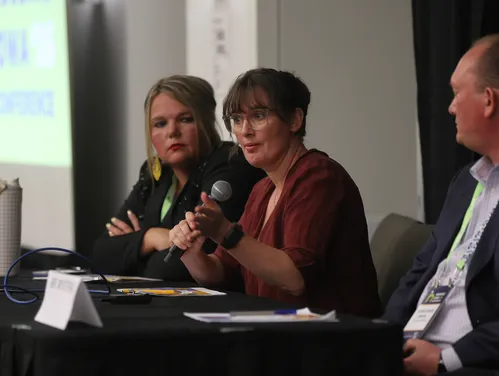 three individuals presenting at a black table