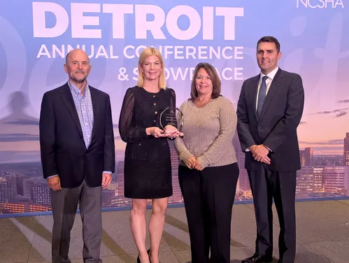 four people standing on a stage accepting an award