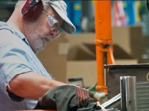 Man working in factory wearing eye and ear protection