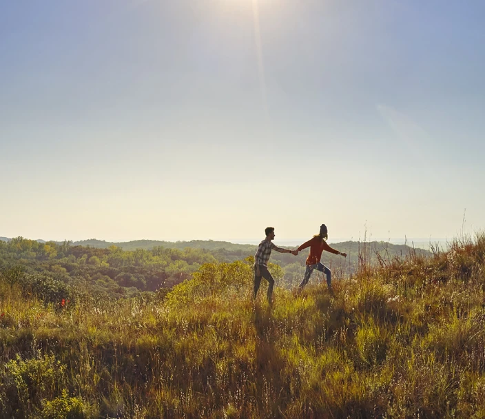 People walking in the hills under a blue sky