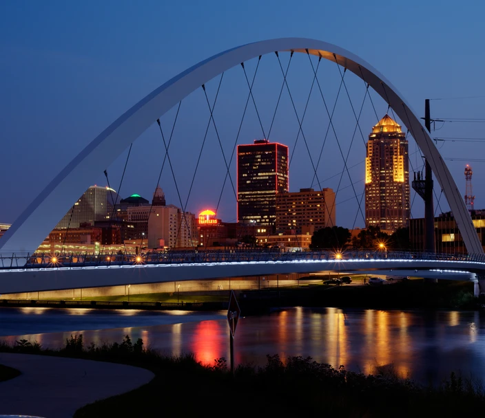 bridge in front of des moines skyline at night