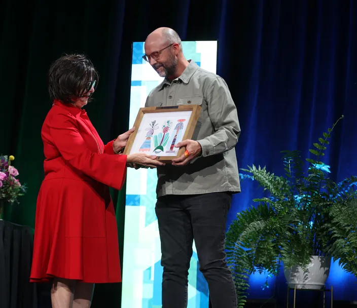 a man accepts an award on stage