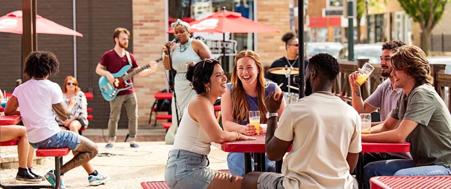 People sitting on a patio eating while listening to live music