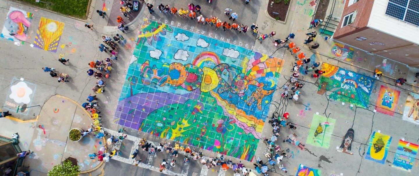 sidewalk art with a crowd viewing it