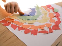 Child working with construction paper making a rainbow