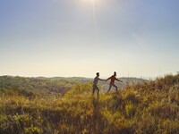 People walking in the hills under a blue sky